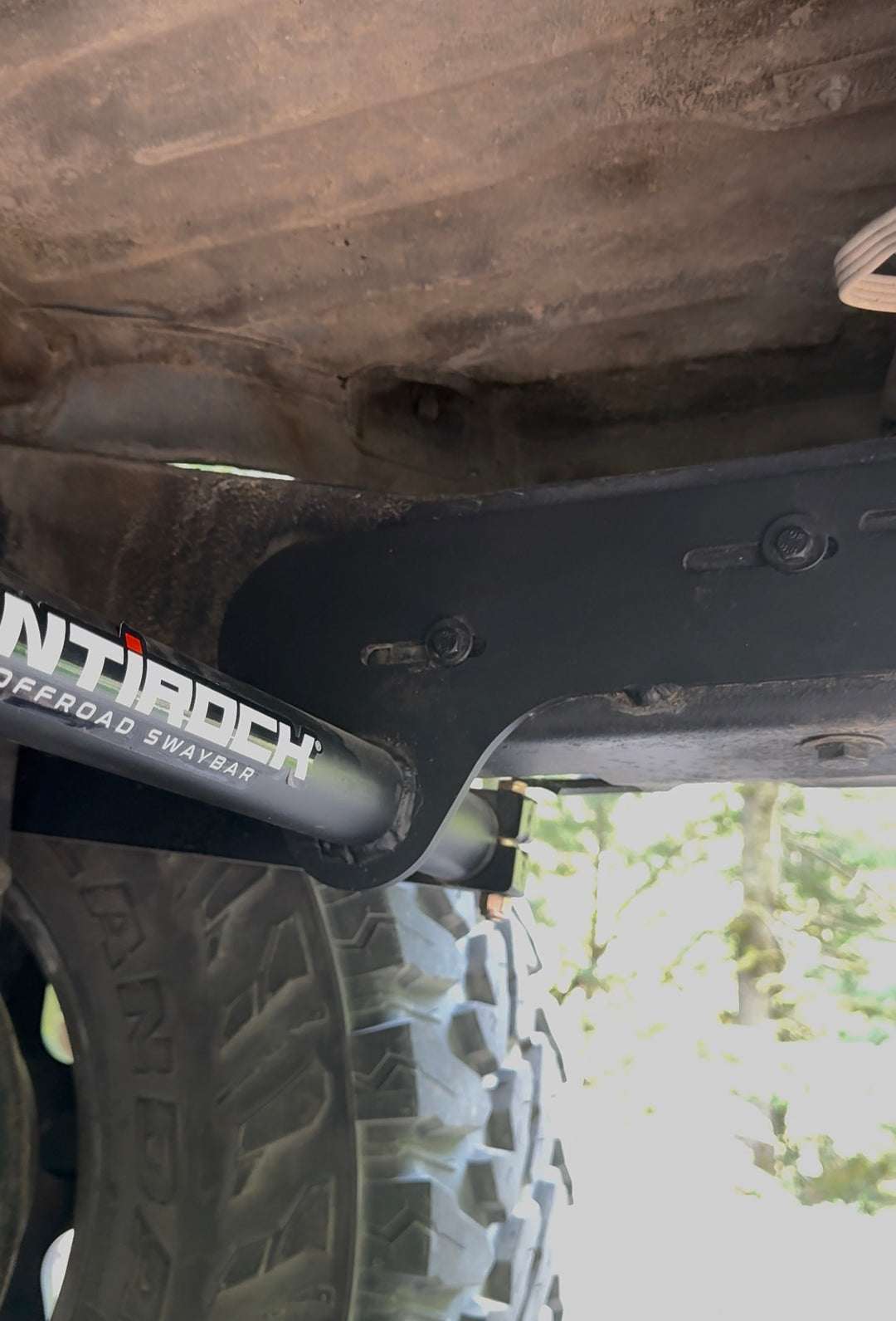 BPF 80 Series Land Cruiser RockJock AntiRock Frame Mounting Plates installed beneath the frame beside the suspension and rugged off road tire