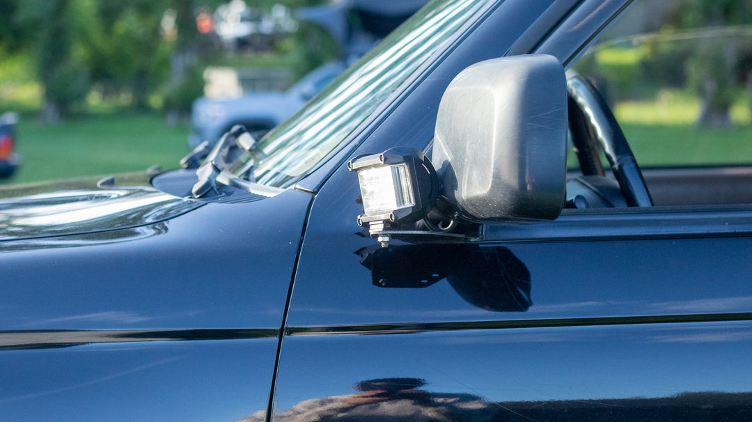 BPF 1996-2002 Toyota 4Runner Light Brackets installed on a black truck, showcasing a durable mounting solution for auxiliary driving lights near the side mirror.