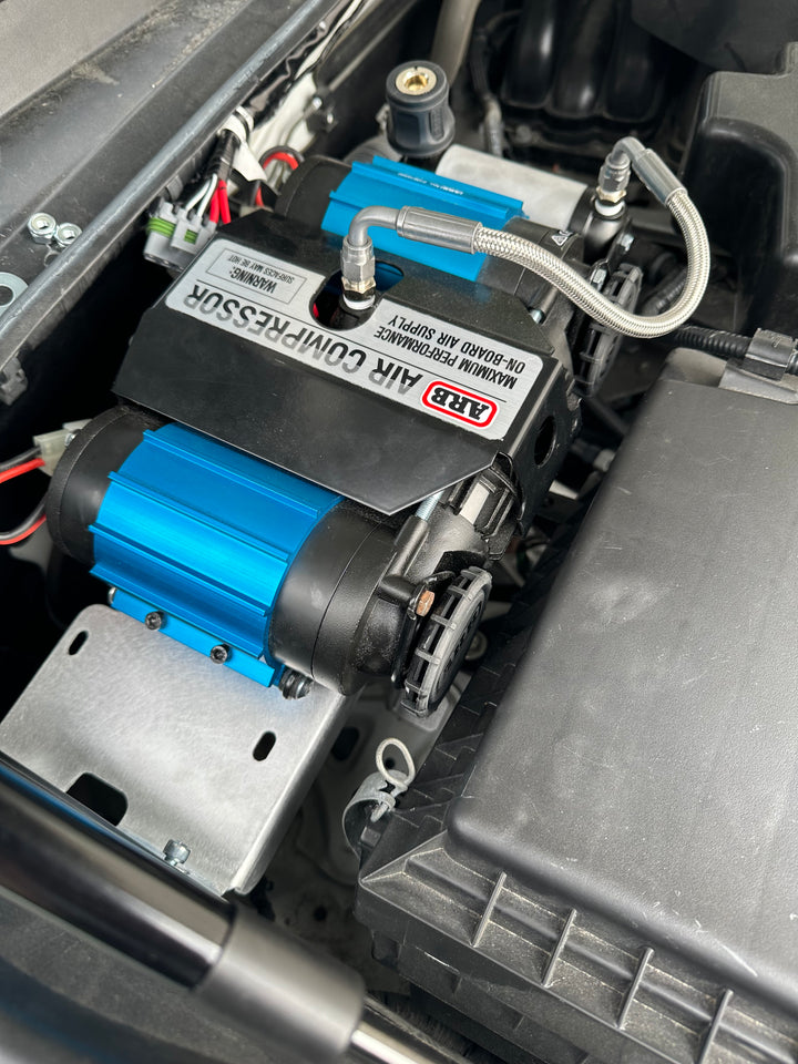 Close-up of an ARB air compressor securely mounted in a vehicle engine bay using the BPF 2016-2023 3rd Gen Tacoma Compressor mount designed for OEM fitment and durable installation.