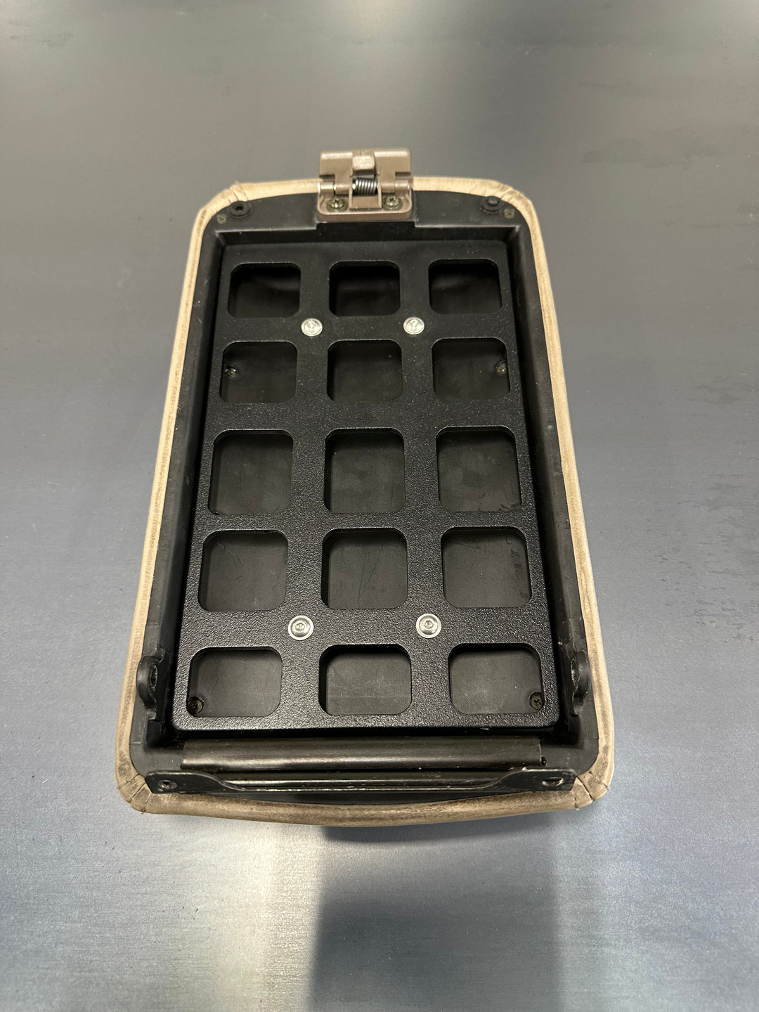 BPF 80 Series Land Cruiser/LX450 Center Console Molle Panel in black metal with multiple rectangular slots designed for secure attachment, mounted inside beige console housing.