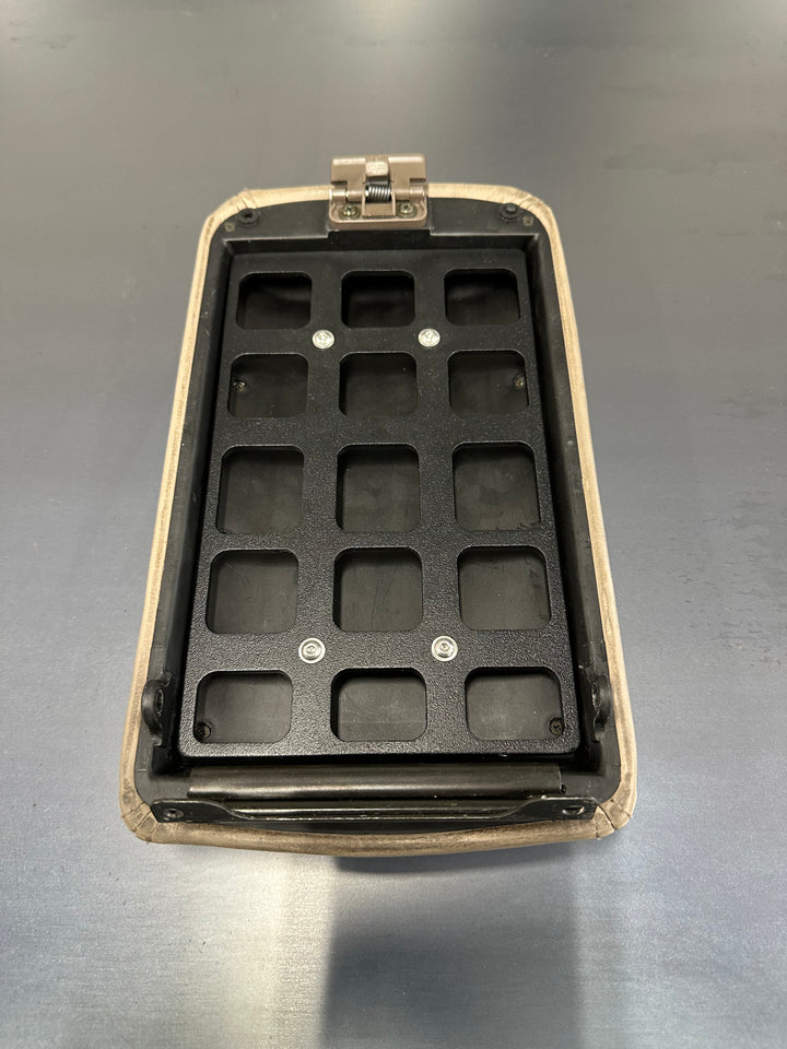 BPF 80 Series Land Cruiser/LX450 Center Console Molle Panel in black metal with multiple rectangular slots designed for secure attachment, mounted inside beige console housing.