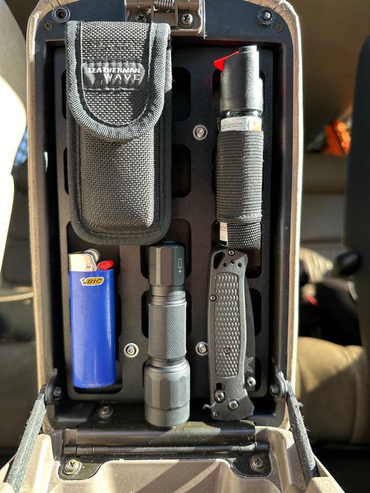 BPF 80 Series Land Cruiser/LX450 Center Console Molle Panel installed with flashlight, folding knife, lighter, and multitool pouch for organized overlanding gear storage.