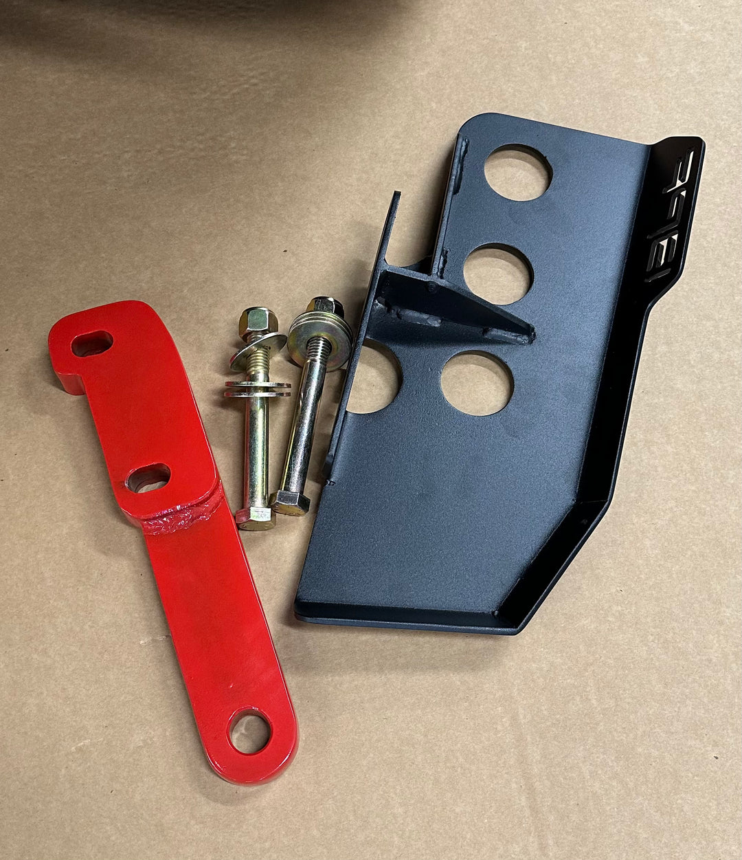 BPF 4th gen Tacoma rear tow hooks with integrated skid plates shown with mounting hardware, featuring a black powder-coated skid plate and a red tow hook bracket designed for durable truck recovery.