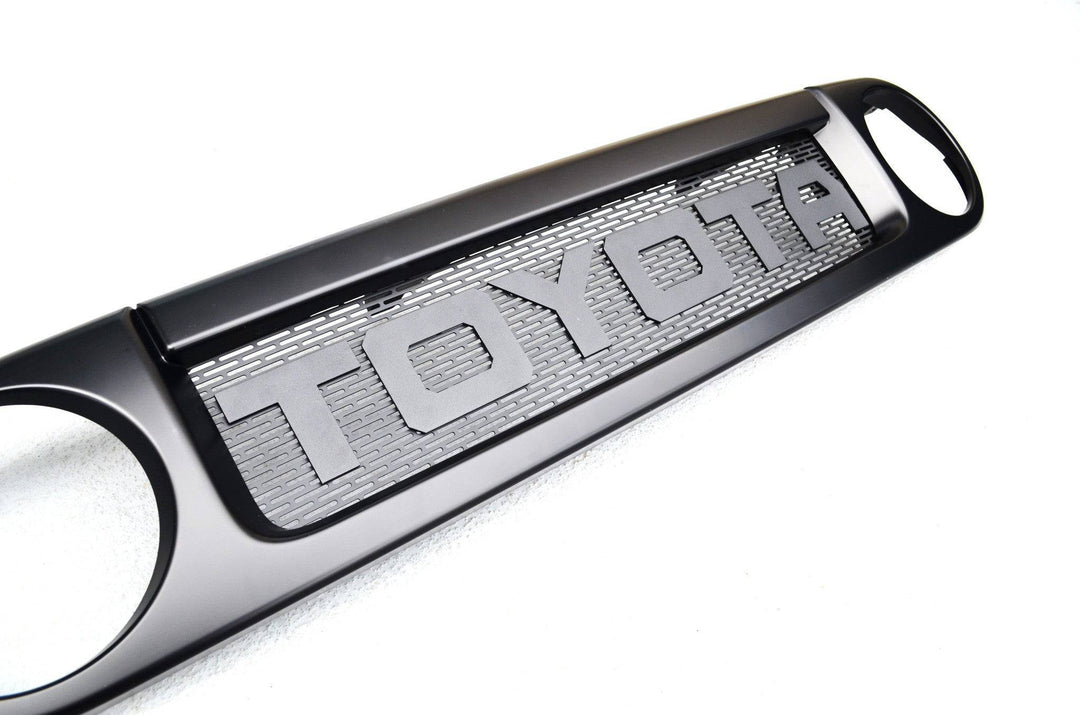 BPF Completed 2007-2014 FJ Cruiser Grill in black with a textured mesh background and bold TOYOTA lettering, designed for OEM fitment and durable performance.