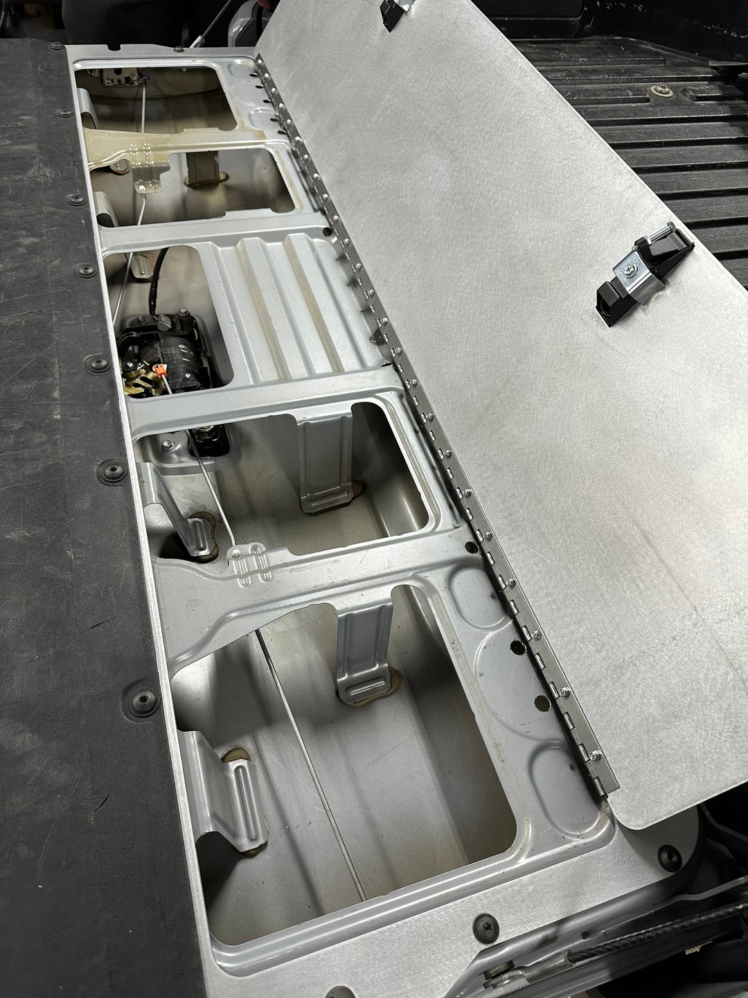 BPF 2016-2023 Toyota Tacoma Tailgate Panel showing the open metal panel revealing compartments beneath the tailgate for secure storage and organization in the truck bed.