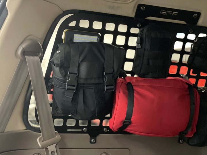 BPF 1990-1997 Toyota Land Cruiser Storage Panels installed inside the vehicle with black and red storage bags attached, showcasing organized overlanding gear and accessory storage.