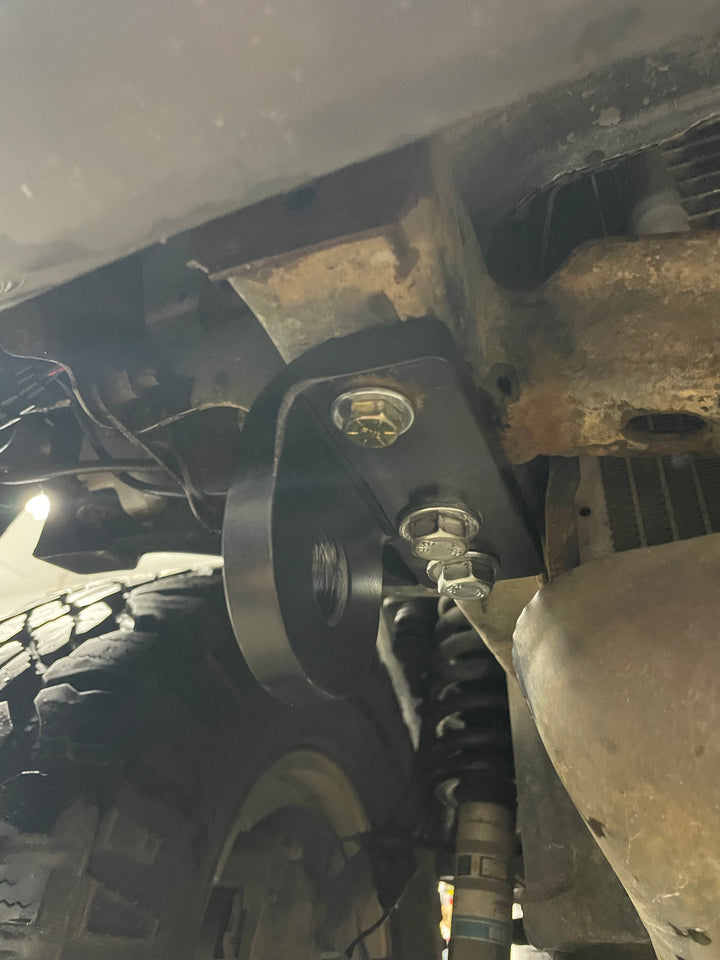 Close-up view of the BPF 3rd gen 4Runner Tow Hook Set 1996-2002 installed on the vehicle frame, showing black powder-coated heavy-duty tow hook and mounting bolts.