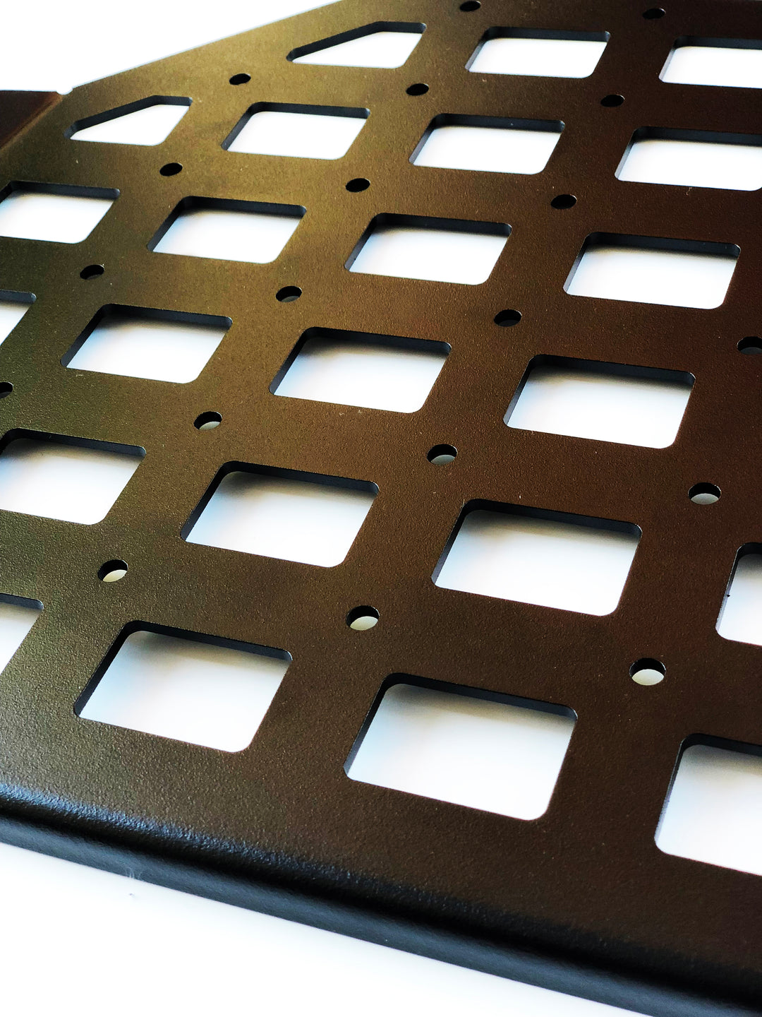 Close-up of a CNC fabricated black metal panel with square cutouts and mounting holes, part of the BPF 2010-2024 4Runner Storage Panels designed for durable overlanding gear organization.