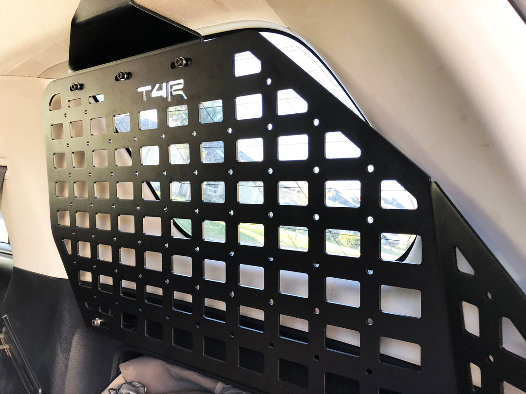 BPF 2010-2024 4Runner Storage Panels installed inside vehicle, showing black powder-coated CNC fabricated metal panel with grid pattern for overlanding gear organization and storage.