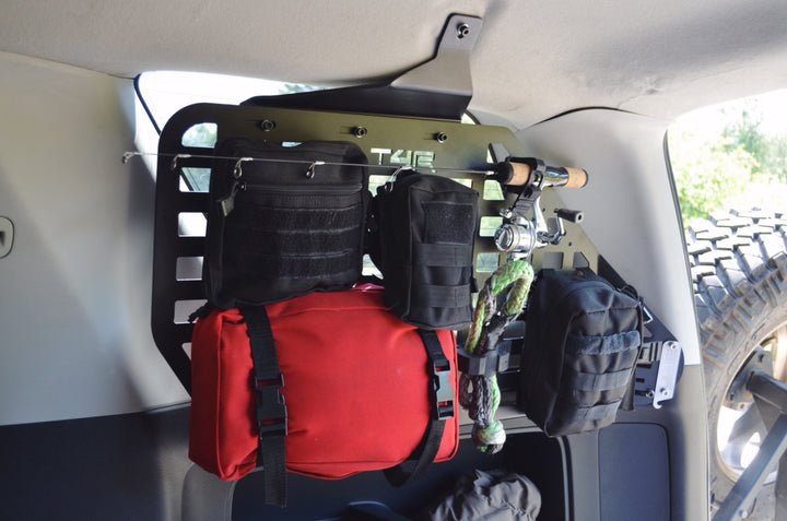 BPF 2010-2024 4Runner Storage Panels mounted inside a vehicle, featuring heavy-duty black powder coated metal with multiple modular pouches and gear organized for overlanding and storage.