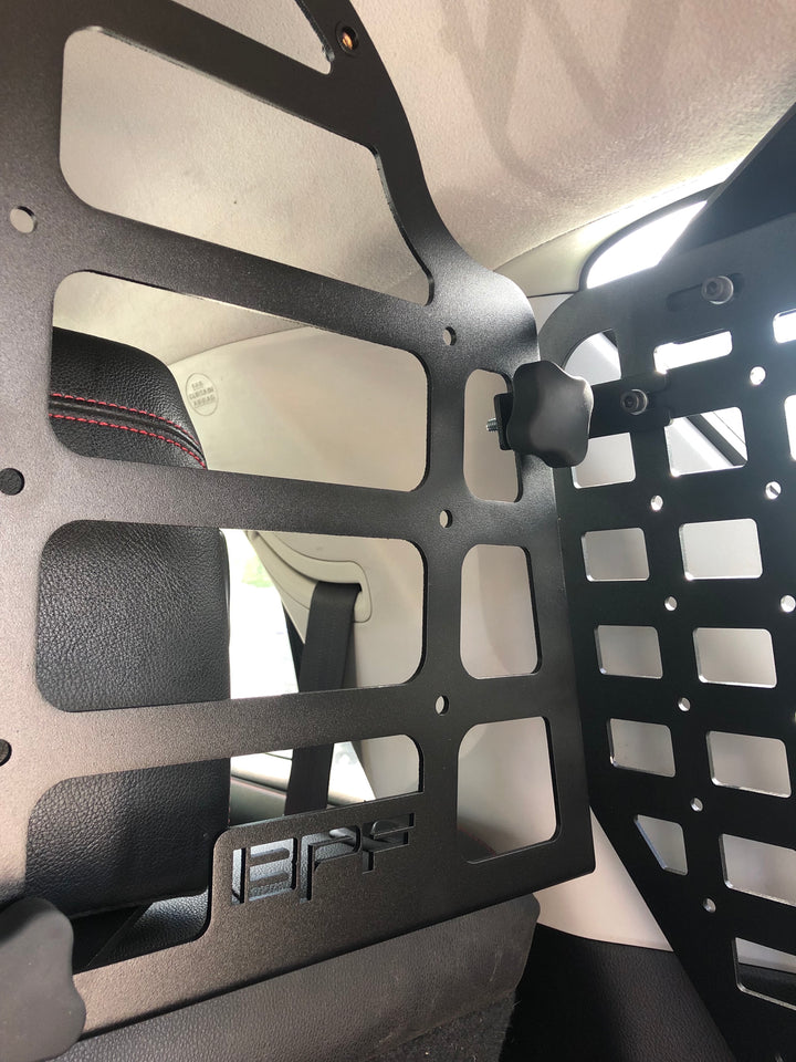 Close-up view of the BPF Molle Style Pet Barrier 5th Gen Toyota 4Runner 2010-2024 installed behind the rear seats, featuring black powder-coated metal with molle panel design and secure mounting knob.