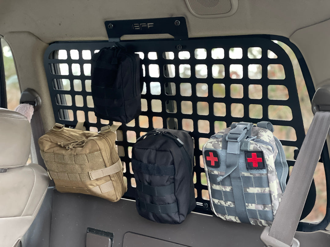 BPF 1990-1997 Toyota Land Cruiser Storage Panels installed inside vehicle rear with attached MOLLE pouches for organized overlanding gear and first aid supplies.