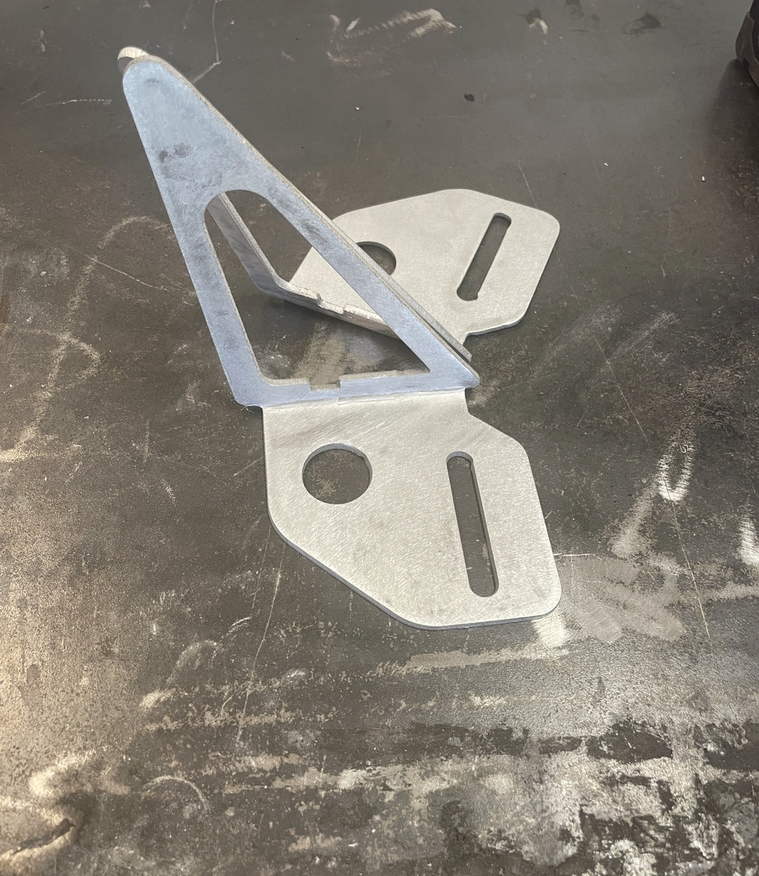 BPF 80 Series Land Cruiser and LX450 Mirror Light Brackets made of metal with cutouts and mounting slots, designed for secure installation and durability.